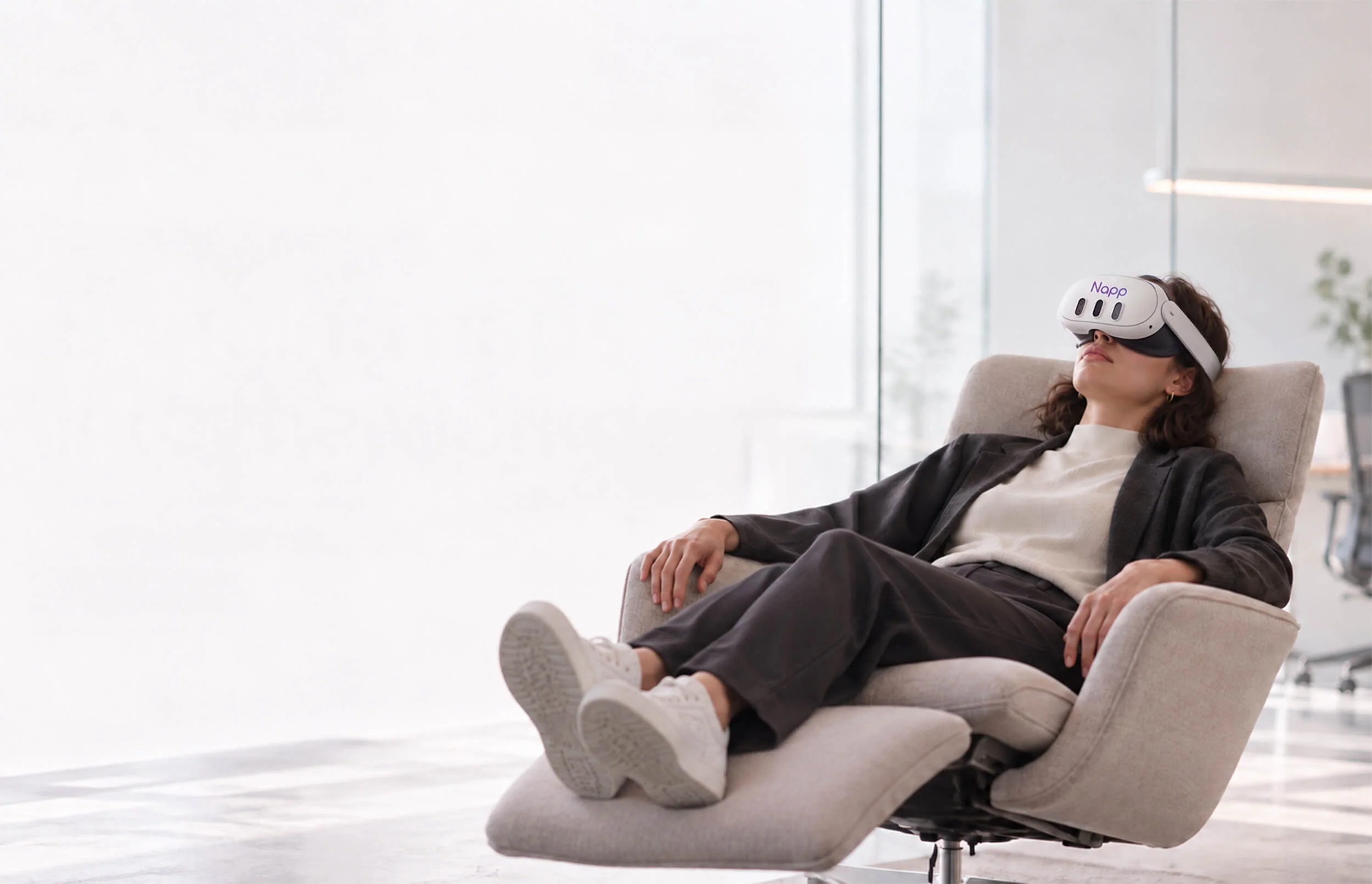 A woman resting in an office armchair wearing a Napp VR headset